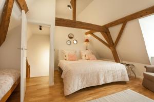 um quarto com vigas de madeira e uma cama com almofadas cor-de-rosa em Skindles Guesthouse em Poperinge