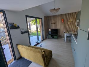 a living room with a couch and a dining room at L'escale du Braou in Audenge