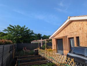 a backyard with a fence and a house at L'escale du Braou in Audenge