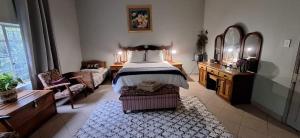 una camera con letto, cassettiera e specchio di Carlsruhe Private Game Reserve Cullinan a Vosburg