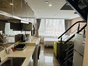 a kitchen with a sink and a living room at Praise Hotel Xujiahui Zikawei Shanghai Stadium 上海徐家汇赞寓酒店上海体育馆地铁站店 in Shanghai