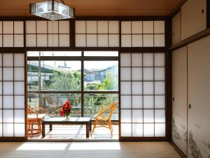 a room with a table and chairs and a large window at ゲストハウスまりん in Higashikagawa
