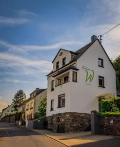 un edificio blanco al lado de una calle en Ferienwohnungen Haus am Würzlaysteig, en Lehmen