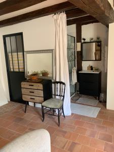 ein Zimmer mit einem Stuhl, einer Kommode und einem Waschbecken in der Unterkunft Maison de charme in Malicorne-sur-Sarthe