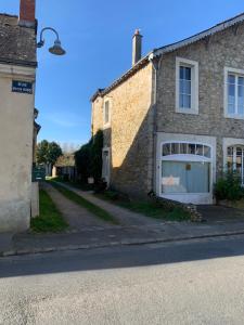 ein Backsteingebäude mit einem Fenster auf einer Straße in der Unterkunft Maison de charme in Malicorne-sur-Sarthe