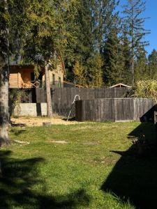 a backyard with a wooden fence and a yard at Fabryka Snów loft w sercu Beskidów in Istebna