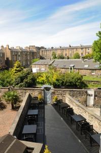 a walkway with benches and tables and buildings at The Hostel in Edinburgh
