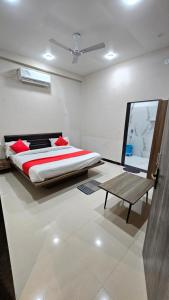 a bedroom with a bed and a table in it at Heaven's Hotel &Resort in Ratlām