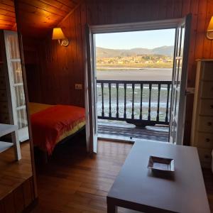 a room with a door open to a balcony with a view at Casa de madera sobre el mar in Nigrán