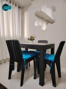 une table de salle à manger noire et des chaises avec des sièges bleus dans l'établissement SMDC Wind Residences Tagaytay City, à Kaybagal