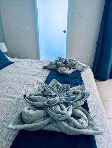 a pile of towels sitting on a bed at Sunset Haven Manikata - Walking distance to Golden Bay in Manikata