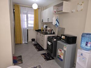 a kitchen with a stove and a refrigerator at Pearls Haven in Kinoo +6 photos