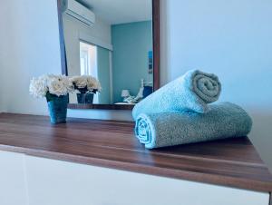 a towel sitting on a counter in front of a mirror at Sunset Haven Manikata - Walking distance to Golden Bay in Manikata