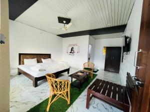 PhataKedar-Kashi Resorts and Resturant的一间卧室，配有一张床、一张桌子和几把椅子