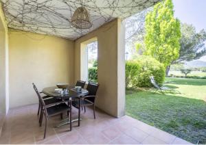 jadalnia ze stołem i krzesłami oraz dziedzińcem w obiekcie Hôtel du Golf de Pont Royal - appartement paisible rez de jardin - terrasse & piscine w mieście Mallemort