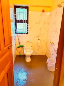 a small bathroom with a toilet and a window at Parvat view in Kotdwāra