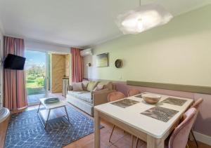 salon ze stołem i kanapą w obiekcie Hôtel du Golf de Pont Royal - appartement paisible rez de jardin - terrasse & piscine w mieście Mallemort