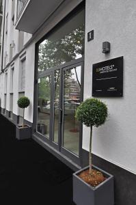 two potted trees sitting outside of a building at BB Hotels Aparthotel Visconti in Milan