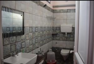 a bathroom with a sink and a toilet at Paradise Mystic Tones in Auroville