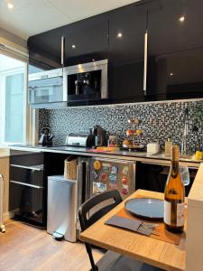 une cuisine avec une table avec une bouteille de vin dans l'établissement CozyStay Beside Historic Bryggen, à Bergen