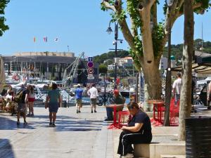 a woman sitting on a bench next to a marina at L'appart Cassis in Cassis
