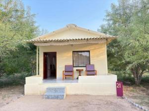 a small house with two chairs and a table at Atithi Luxury Resort in Pushkar