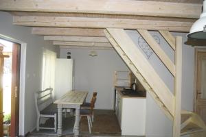 a kitchen with a table and a staircase in a room at Domek nad rzeką Słupią z jacuzzi in Sulęczyno