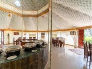 a room with a table and chairs and a room with tables at Atithi Luxury Resort in Pushkar +34 photos