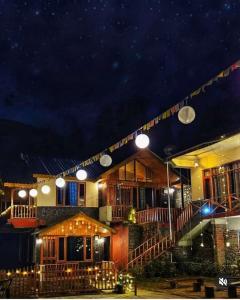 ein Gebäude mit einer Lichterkette in der Nacht in der Unterkunft Majestic View Cottages in Jibhi
