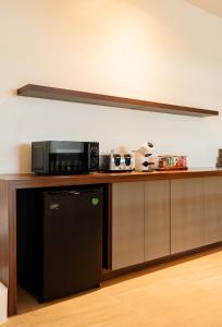 a kitchen with a microwave and a black dishwasher at SOL HOUSE kohlarn in Ko Larn