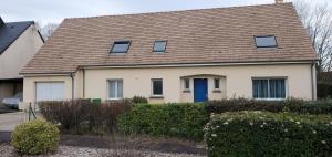 a house with a brown roof and a blue door at Chambre à louer proche circuit 24h in Changé
