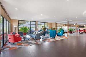 un vestíbulo con sillas coloridas, mesas y ventanas en Comfort Suites Oxford I-20 exit 188, en Oxford