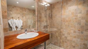 a bathroom with a sink and a shower at Hôtel Amphithéâtre in Arles