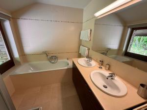 a bathroom with two sinks and a bathtub and a tubermott at L'Écrin de la Warche in Malmedy +4 photos