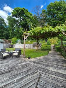 a wooden deck with two benches and a picnic table at Coco-lak Vendégház in Sopron
