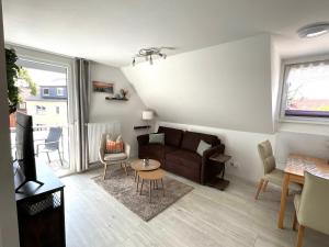 a living room with a couch and a table at Apartement Seestern mit kleinem Südbalkon, 100m zum Meer in Steinhude