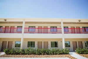 an exterior view of a building with red and blue balconies at Palace Inn 290 & Jones Rd in Houston