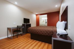 a hotel room with a bed and a desk at Palace Inn 290 & Jones Rd in Houston