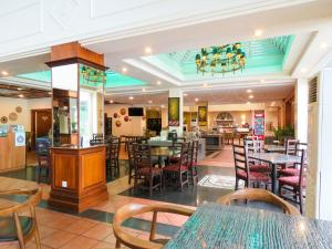 a restaurant with tables and chairs and a bar at StarLodge in Kampong Jerudong
