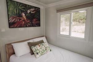a room with a bed with a window and a painting at Erato's Cottage in Plaka