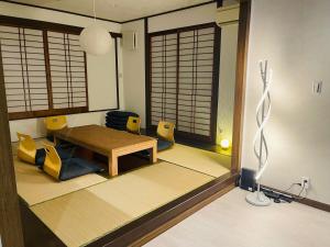 a living room with a wooden table and chairs at New AirportHills 1400ｍ2 絶景露天風呂1棟2階貸切 駐車場4台 サウナ BBQ施設 ペット in Hakata +49 photos