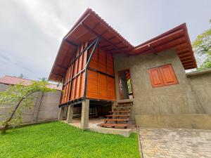 a small house with a wooden facade on a yard at Villa Lee in Ragama