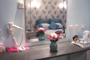 a vanity with a mirror and flowers in a room at Talybont B&B Aberystwyth in Talybont