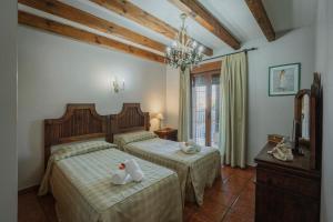 une chambre avec deux lits avec des serviettes dessus dans l'établissement Casa rural Las Eras de Riofrio, à Ríofrío