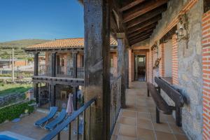 un balcon extérieur d'une maison avec un banc dans l'établissement Casa rural Las Eras de Riofrio, à Ríofrío