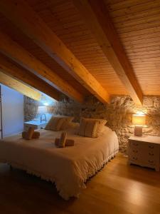a bedroom with a large bed in a stone wall at La Casuca De la Iglesia in Ubiarco