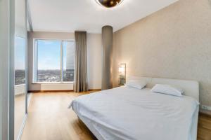 タリンにあるSkyResidence Amazing Luxury View Apartment HIGH23Fの白いベッドと大きな窓のある寝室