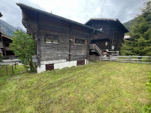 a log cabin with a grass field in front of it at Magnificent chalet Opa in Reckingen - Gluringen