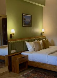 Un dormitorio con dos camas y una pared verde. en Paramount Apartment & Rooms, en Pokhara