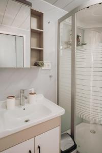 a white bathroom with a sink and a shower at Erato's Cottage in Plaka +13 photos